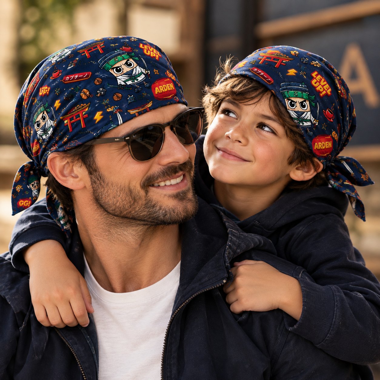 Father and son smiling together, both wearing the ARDEN navy ninja-character bandana as headscarves