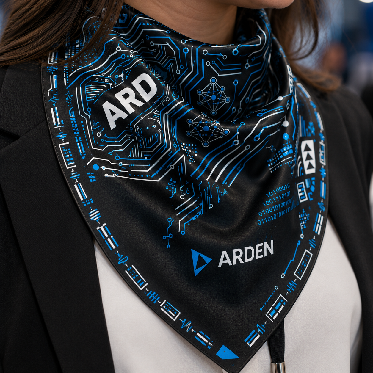 Close-up of the ARDEN black and blue circuit-print bandana worn at the neck, showing the ARDEN mark and circuit details